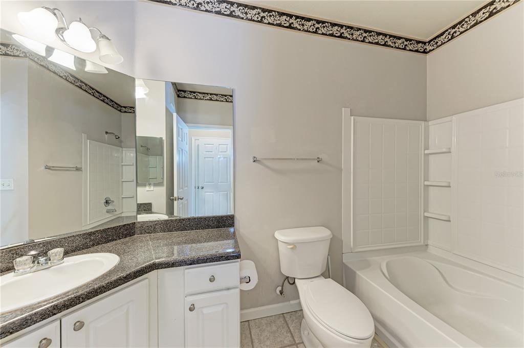 4802 51st Street West, Unit 1122 Bradenton, FL 34210 - Photo 29 of 37 a bathroom with a granite countertop sink toilet mirror and shower