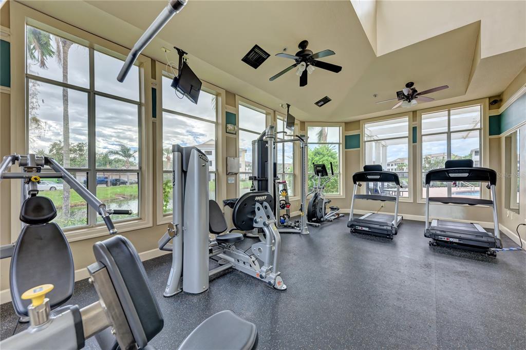 4802 51st Street West, Unit 1122 Bradenton, FL 34210 - Photo 36 of 37 a view of a livingroom with furniture water floor to ceiling windows and a ceiling fan
