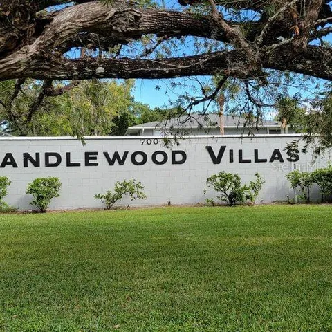 a view of a white house with a big yard and large tree