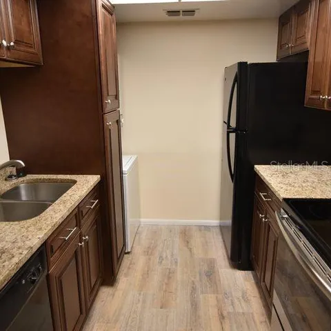 a kitchen with a sink stove and refrigerator