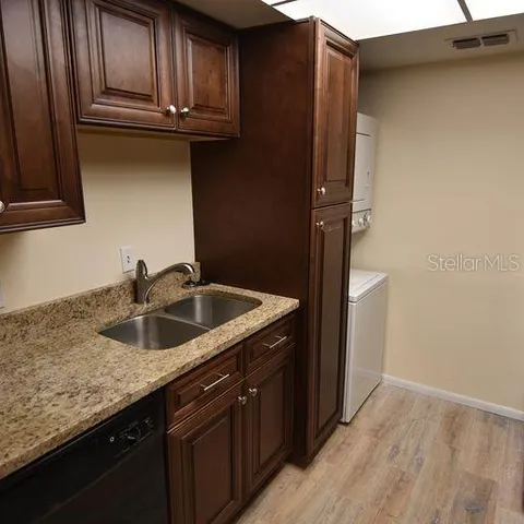 a kitchen with granite countertop stainless steel appliances wooden cabinets and a sink