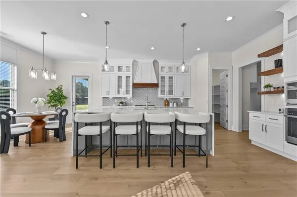 a large kitchen with stainless steel appliances granite countertop a lot of counter space and wooden floors