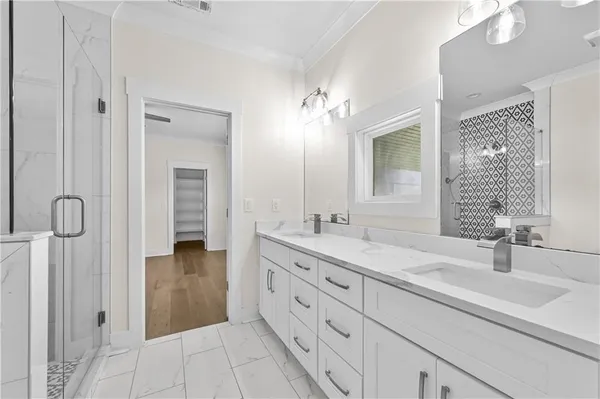 a bathroom with a granite countertop sink a mirror and a shower