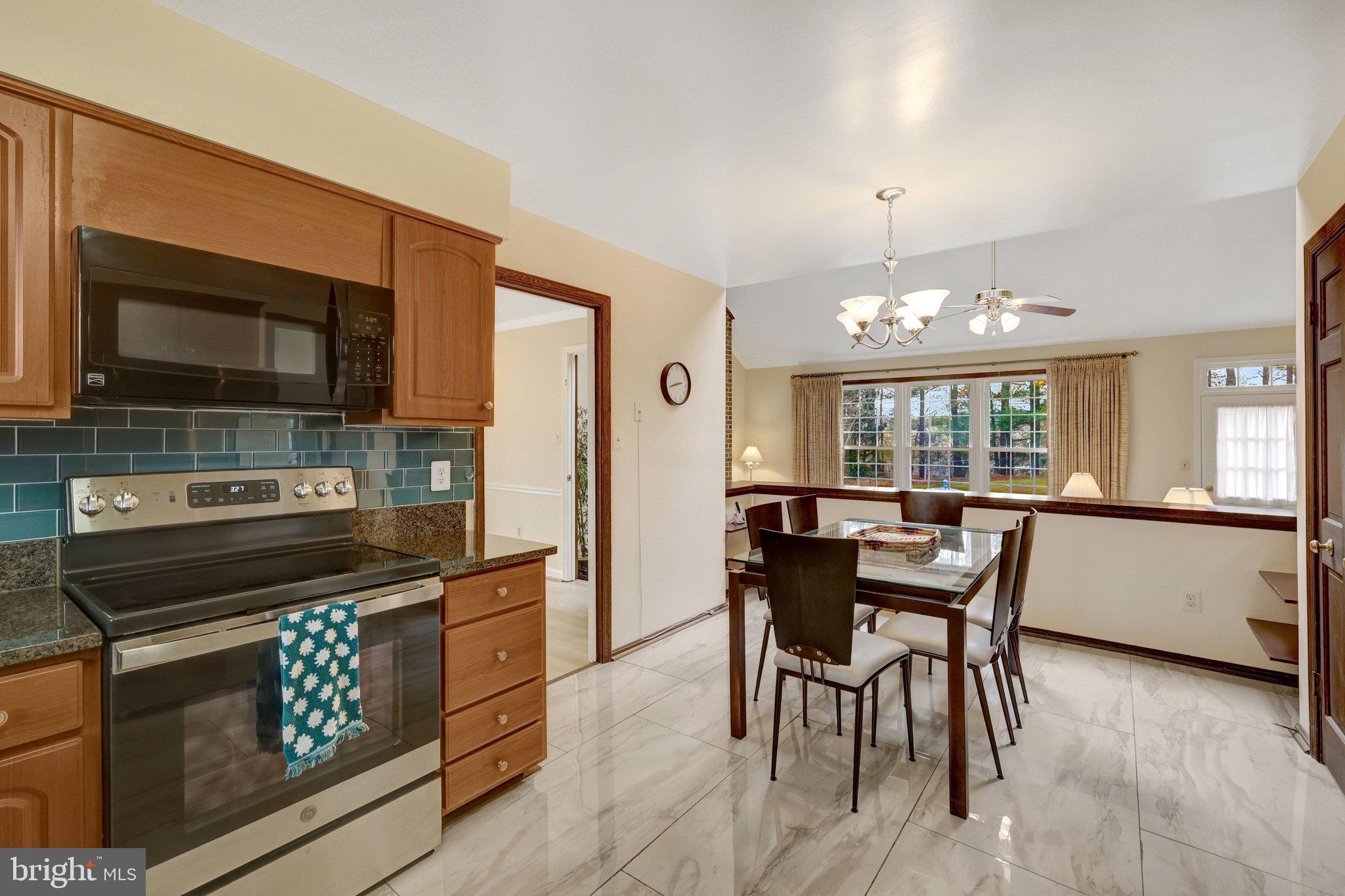 1398 Park Lake Drive Reston, VA 20190 - Photo 22 of 64 a kitchen with a stove a microwave and dining table