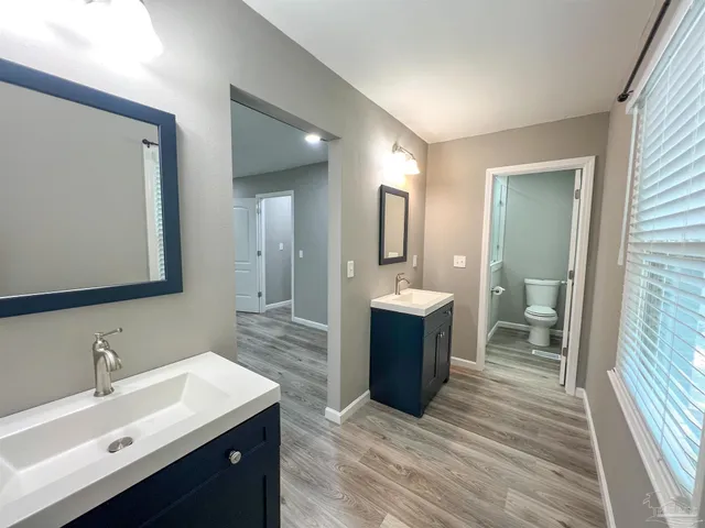 a spacious bathroom with a bathtub sink mirror and toilet