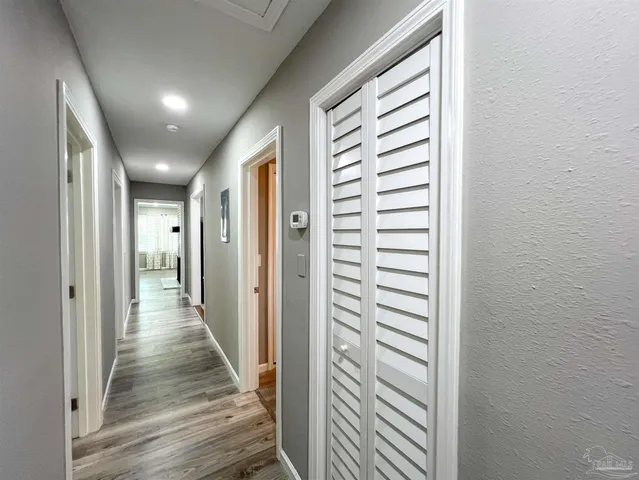 a view of a hallway with wooden floor and closet