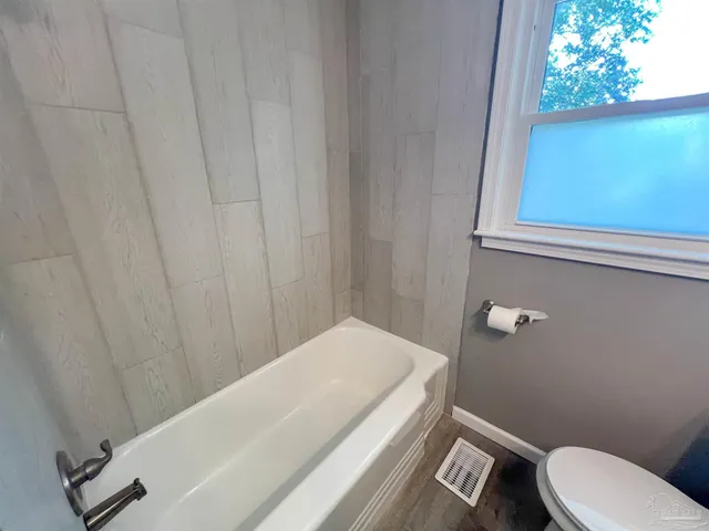 a bathroom with a white toilet and a shower curtain