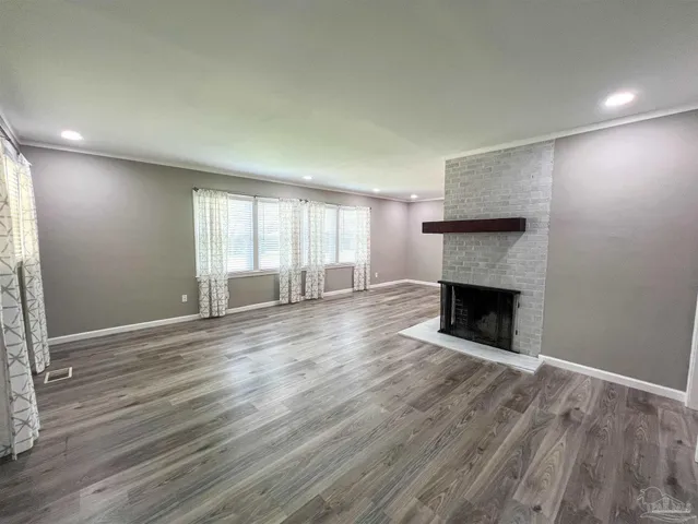 an empty room with wooden floor and fireplace