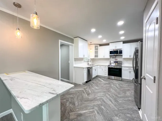 a kitchen with a sink a counter top space stainless steel appliances and cabinets