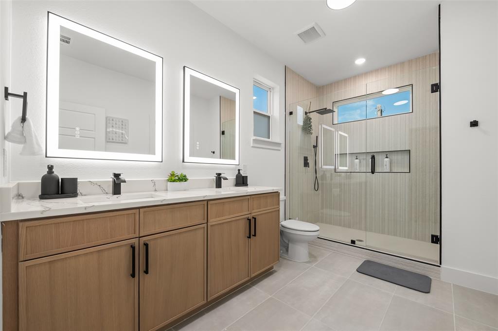 2701 Birmingham Avenue Dallas, TX 75215 - Photo 17 of 21 a bathroom with a double vanity sink toilet and shower