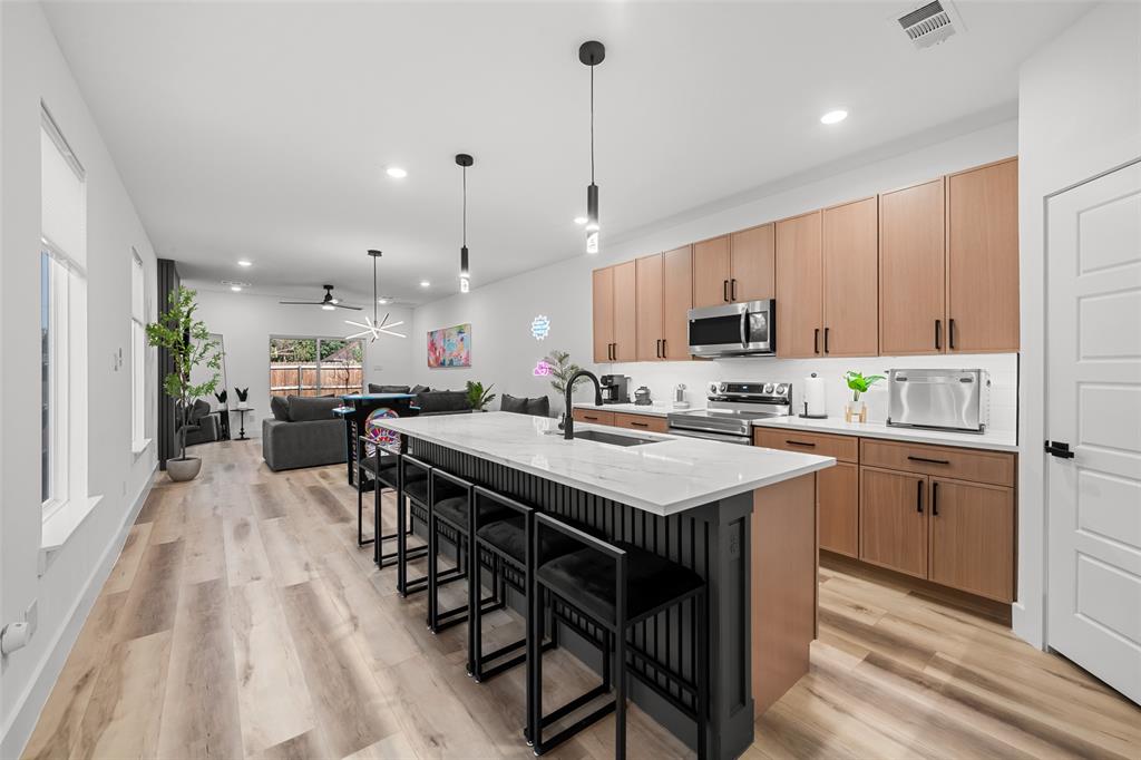 2701 Birmingham Avenue Dallas, TX 75215 - Photo 21 of 21 a kitchen with stainless steel appliances kitchen island granite countertop a table chairs sink and cabinets