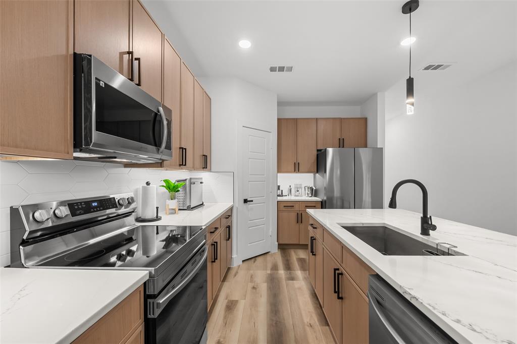 2701 Birmingham Avenue Dallas, TX 75215 - Photo 3 of 21 a kitchen with stainless steel appliances a sink dishwasher a stove top oven a refrigerator with island and cabinets
