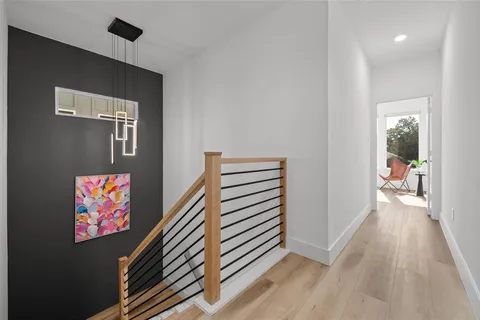 a view of a hallway to a house with wooden floor and stairs