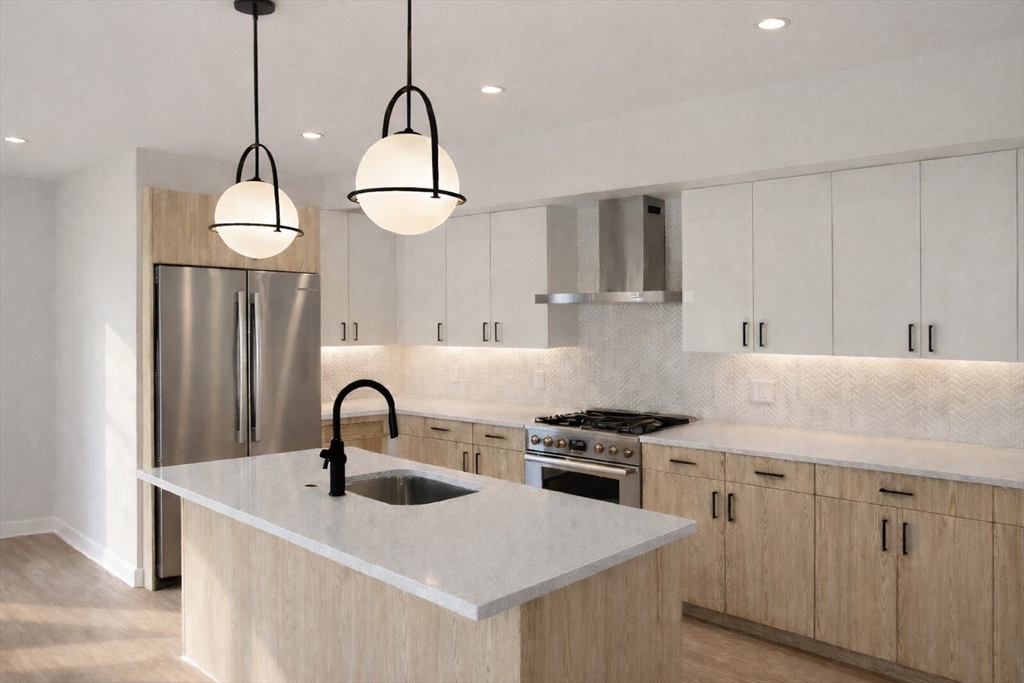a kitchen with stainless steel appliances a sink stove and cabinets