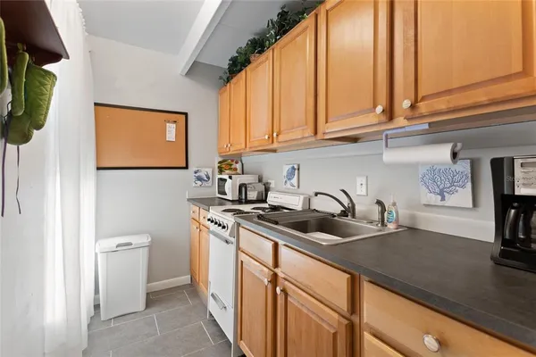 a kitchen with stainless steel appliances granite countertop a sink a stove and a wooden cabinets