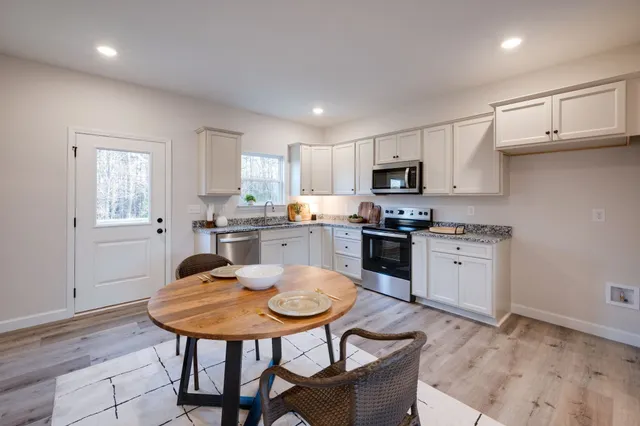 a kitchen with a stove a sink a microwave and cabinets