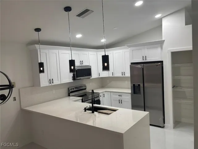 a kitchen with stainless steel appliances a refrigerator sink and microwave