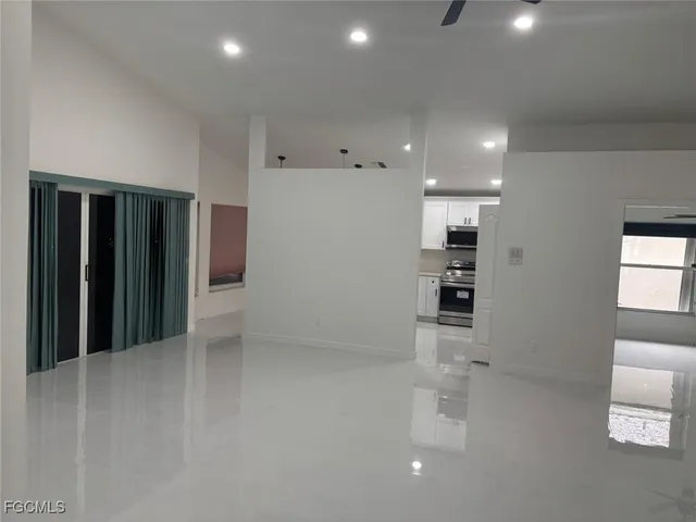 wooden floor in an empty room with a kitchen