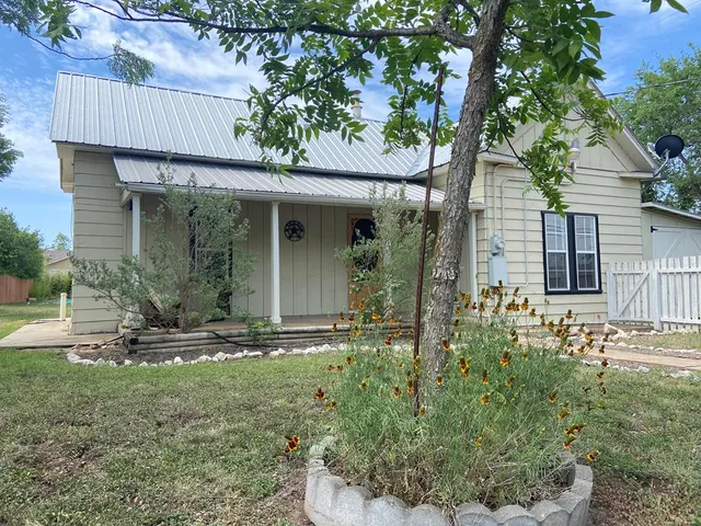 a backyard of a house with table and chairs