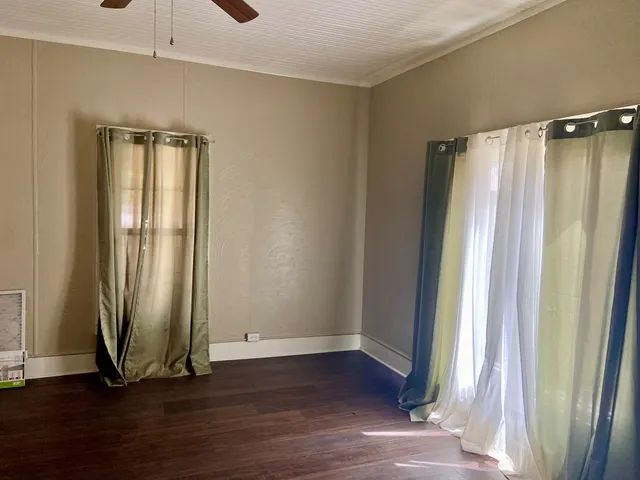 an empty room with wooden floor and entrance