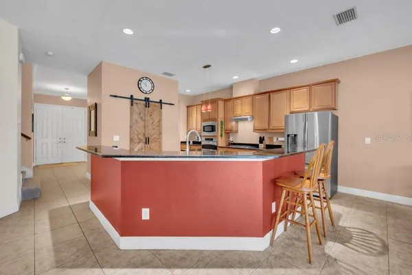 a large kitchen with stainless steel appliances granite countertop a stove a sink and a microwave