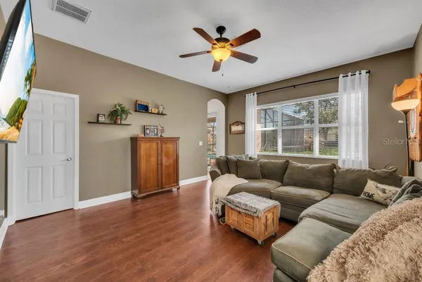 a living room with furniture kitchen view and a large window