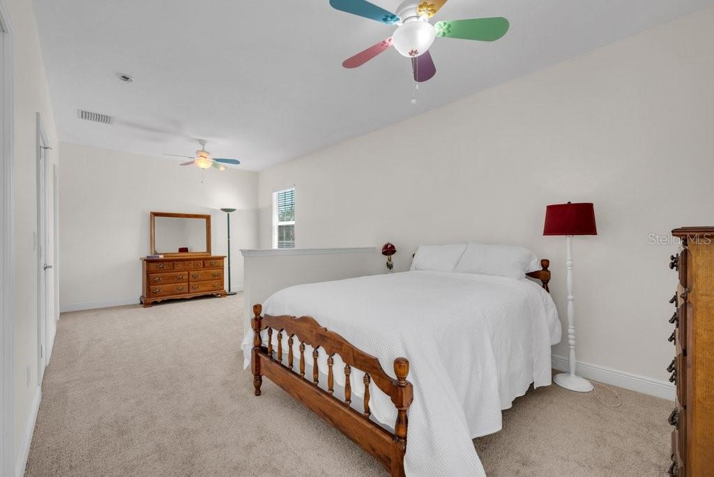 5920 Fishhawk Crossing Boulevard Lithia, FL 33547 - Photo 34 of 61 a bedroom with a bed and a chandelier