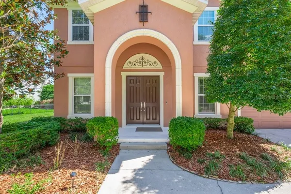 a view of a brick house with a large windows and a large tree