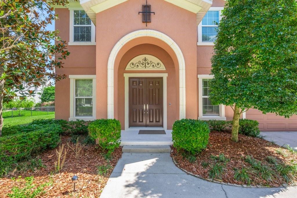 5920 Fishhawk Crossing Boulevard Lithia, FL 33547 - Photo 5 of 61 a view of a brick house with a large windows and a large tree