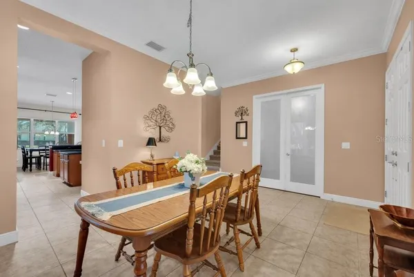 a large kitchen with kitchen island a large counter top dining table and stainless steel appliances