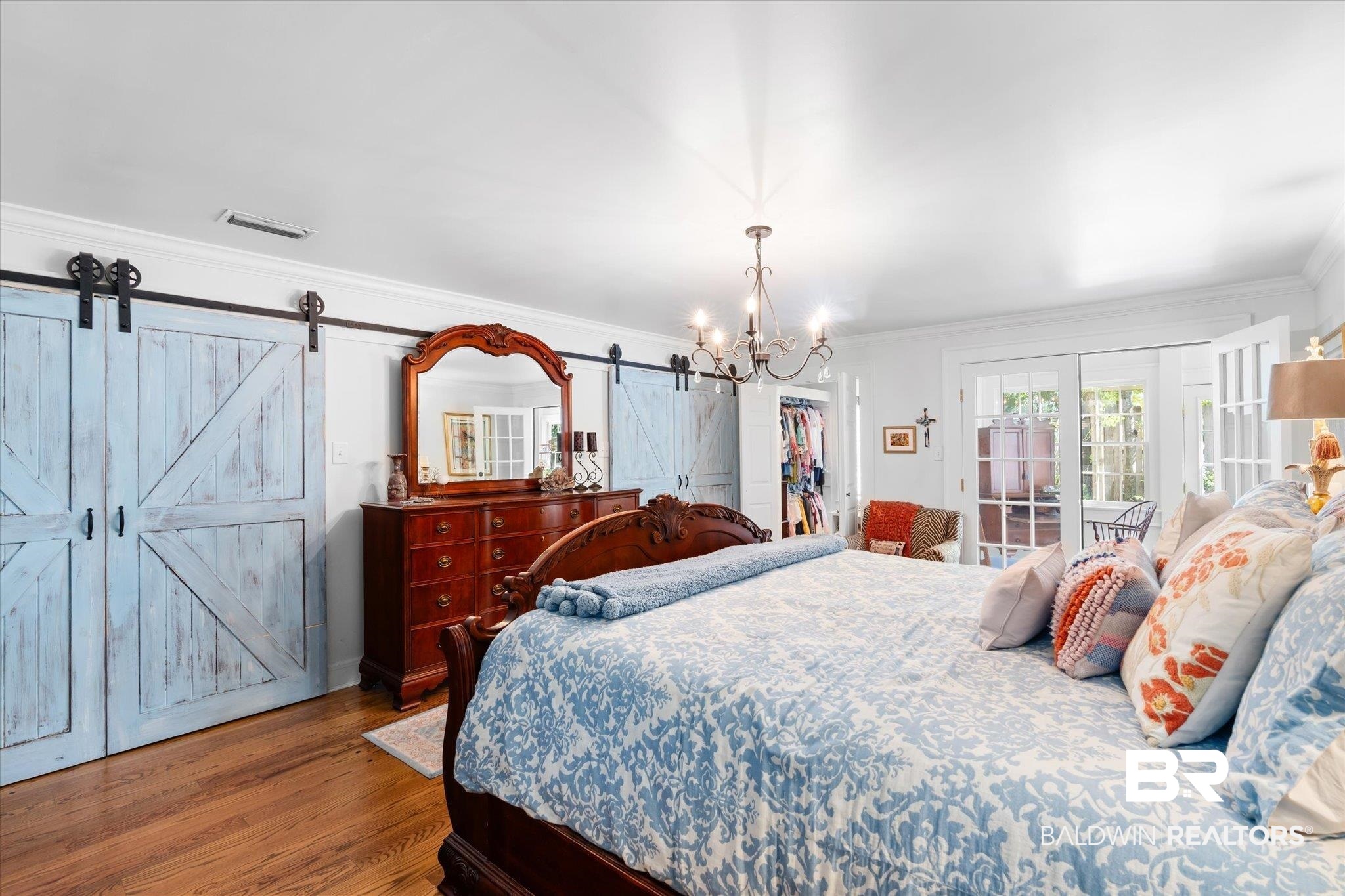 202 Woodlands Avenue Mobile, AL 36607 - Photo 13 of 53 Bedroom featuring crown molding, hardwood / wood-style flooring, an inviting chandelier, and a barn door