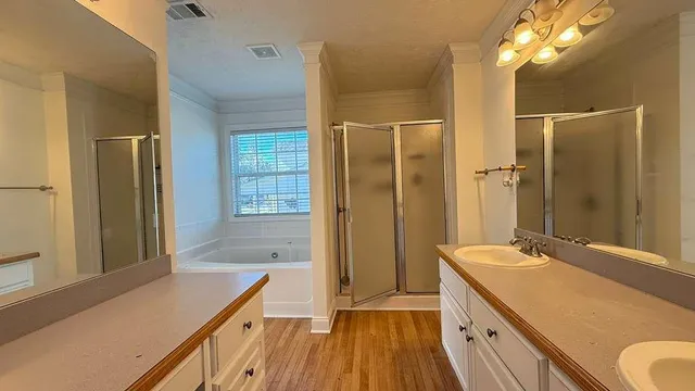 a bathroom with a granite countertop sink a large mirror and a shower