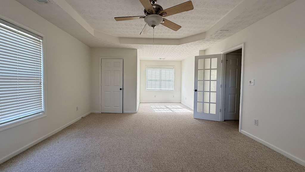 3860 Morgan Road Buford, GA 30519 - Photo 14 of 21 en empty room with windows and ceiling fan