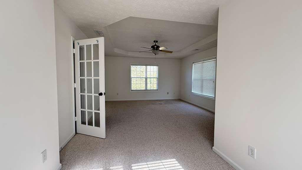 3860 Morgan Road Buford, GA 30519 - Photo 15 of 21 an empty room with windows and ceiling fan