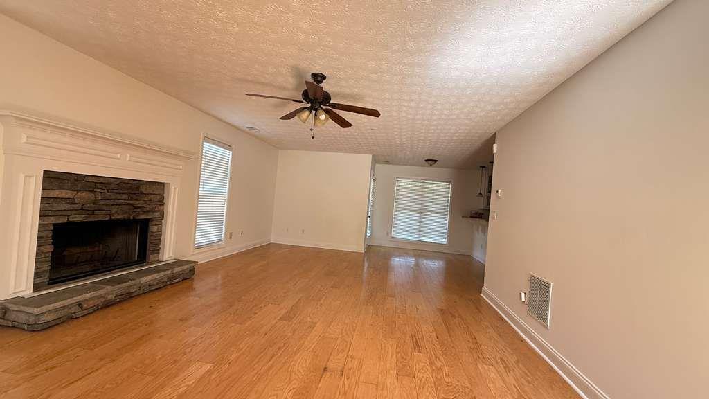 3860 Morgan Road Buford, GA 30519 - Photo 4 of 21 a view of empty room with wooden floor and fireplace
