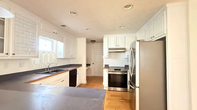 a kitchen with stainless steel appliances granite countertop a refrigerator and a sink