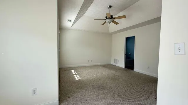 an empty room with a ceiling fan and a window