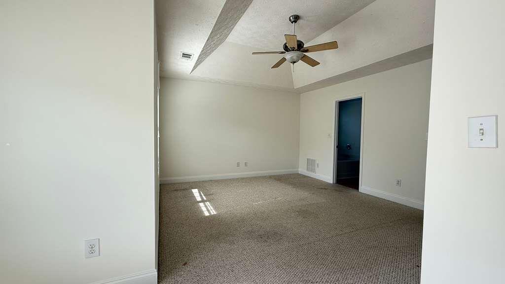 3860 Morgan Road Buford, GA 30519 - Photo 10 of 21 an empty room with a ceiling fan and a window