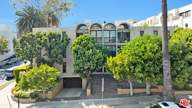 a front view of a house with a yard and a garden