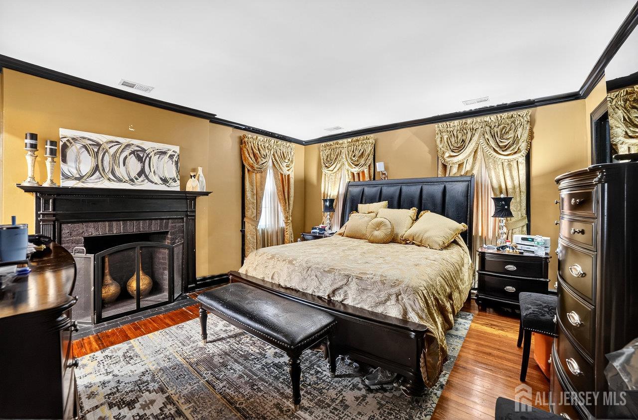 101 West Hill Road Colonia, NJ 07067 - Photo 33 of 52 a bed sitting in a bedroom next to a fireplace