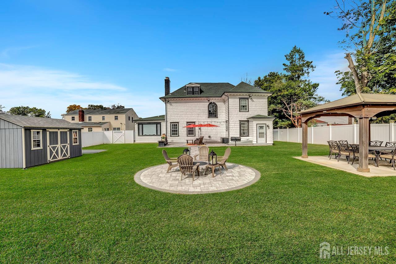 101 West Hill Road Colonia, NJ 07067 - Photo 42 of 52 a white house with a table and chairs under an umbrella