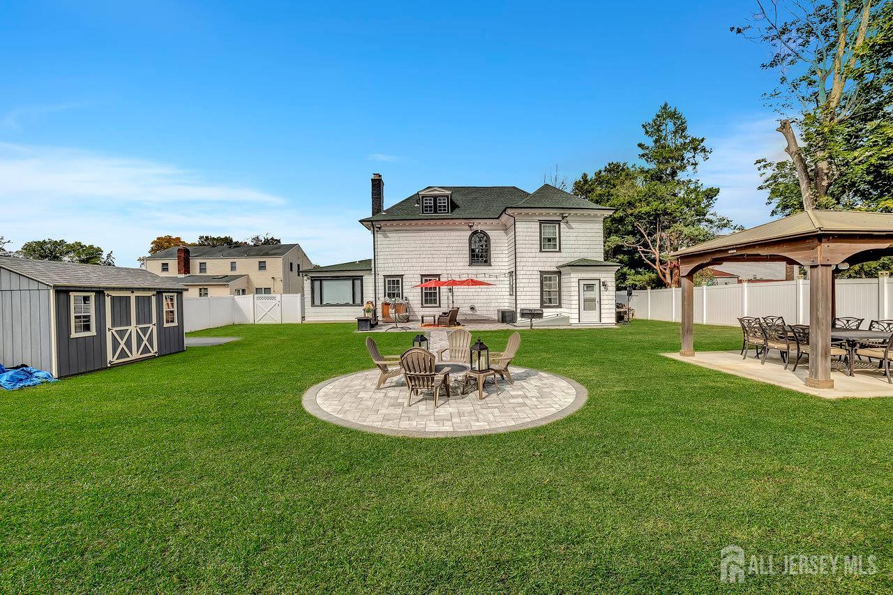 101 West Hill Road Colonia, NJ 07067 - Photo 47 of 52 a white house with a table and chairs under an umbrella