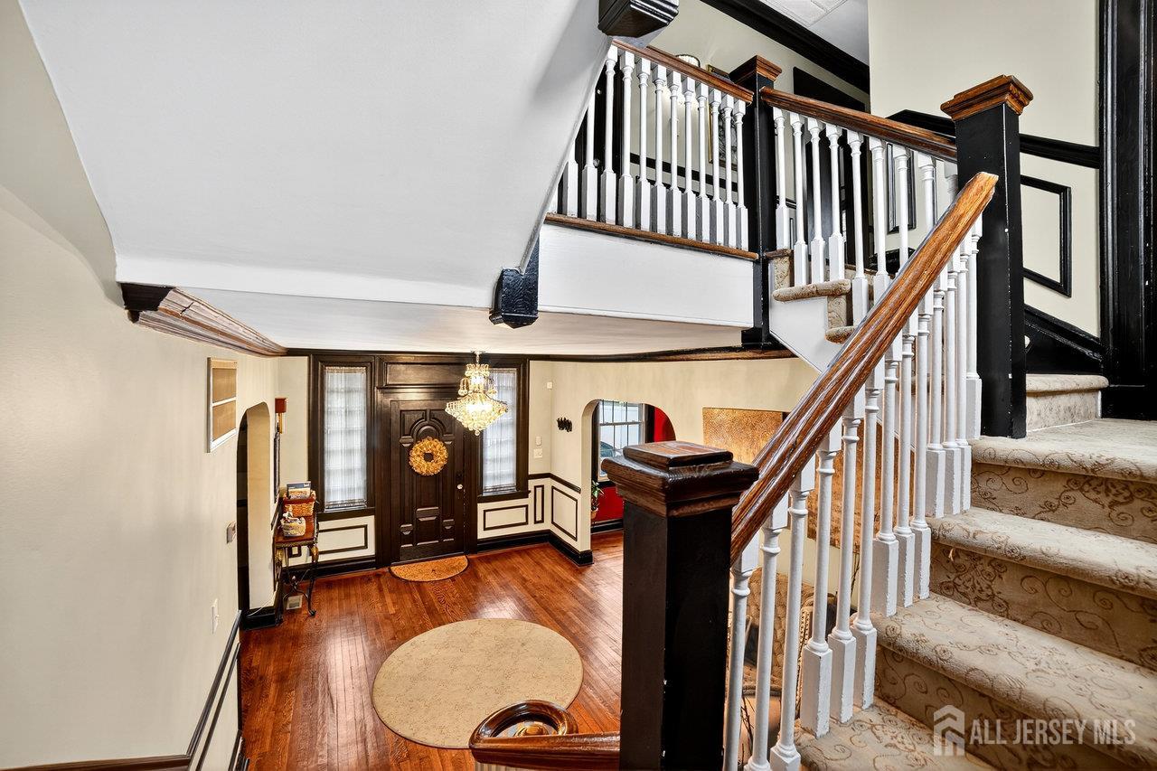 101 West Hill Road Colonia, NJ 07067 - Photo 10 of 52 a view of staircase with wooden floor and a chandelier