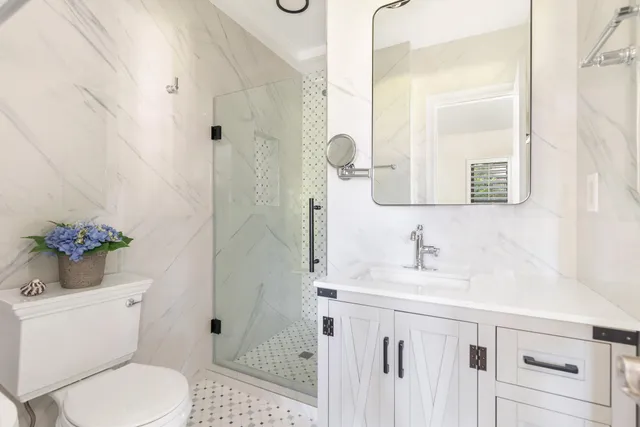 a bathroom with a sink a toilet and shower