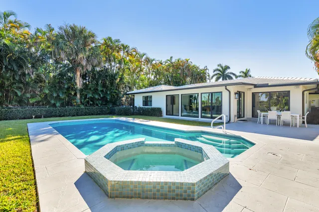 a view of a house with swimming pool and a yard