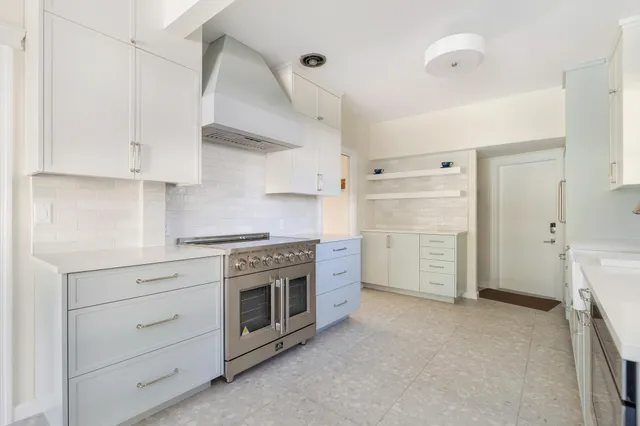a kitchen with white cabinets and white appliances