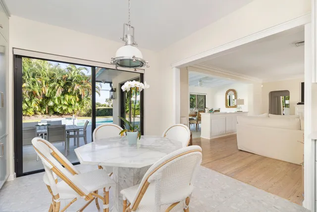 a dining room with furniture a chandelier and wooden floor