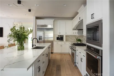 a kitchen with stainless steel appliances granite countertop a sink a stove and a refrigerator