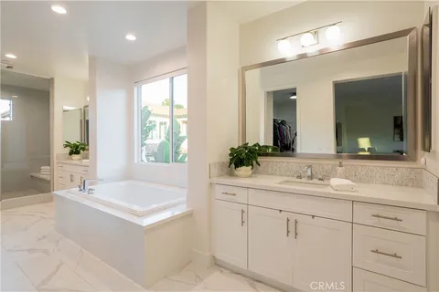 a bathroom with a sink a large mirror and a bathtub
