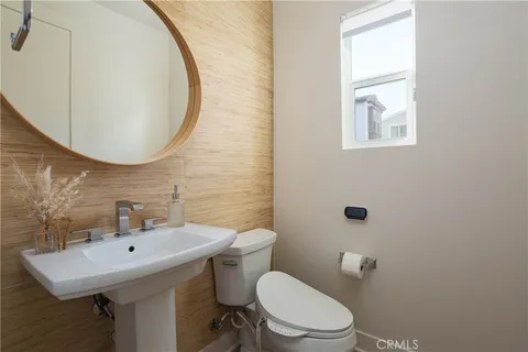 a bathroom with a toilet a sink and mirror